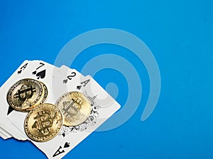 Photo of bitcoins and card games against blue background. Poker games and gambling concept.