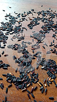 Photo of black glutinous rice splattered on the wooden table