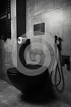 Photo of black matte bathroom details, with dark grey walls. Modern interior.