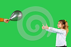 Photo with blank advertising space. The girl shows both fingers with thumb up on the ultimate gray balloon and smiles