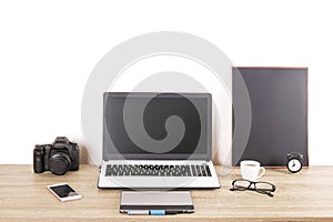 Photo blogger / photographer / it specialist`s typical office space table with laptop, blank screen, coffee cup and electronics.