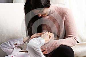 Photo of blond and brunnete girlfriends lesbian couple making fun at home, one girl closes eyes with hands.