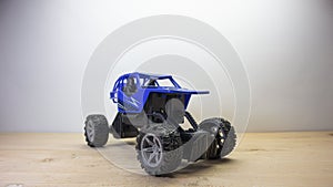 Photo of a blue radio controlled offroad sports car racing toy car  on a wooden base