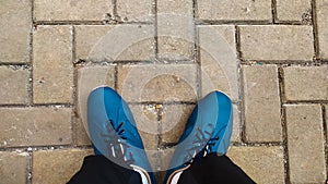photo of blue shoes in the middle of a pedestrian street