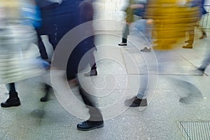 Photo of blurred people in motion who are walking to a transport stop