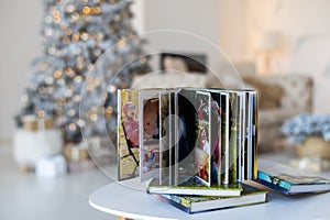 Photo book album under the Christmas tree surrounded by Christmas gifts