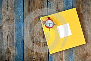Photo book cover with empty frame and clock on a wooden background