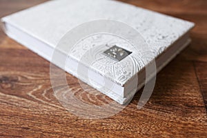 Photo book with a cover of genuine leather. White color with decorative stamping. Close up picture