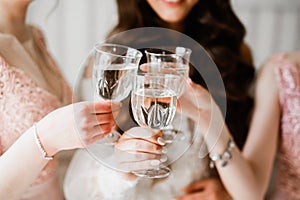 Photo bride with her friends drinking champagne from glasses