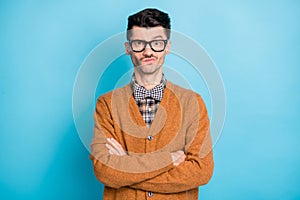 Photo of brown haired young guy folded arms raise eyebrow distrust isolated on pastel blue color background