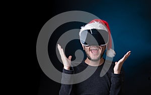 Photo of brunet in Santa`s cap and glasses of virtual reality