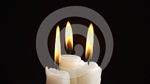 Photo of the burning a three candles on black background