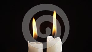 Photo of burning a two candles on black background