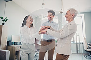 Photo of business people man women put hands together team building in office