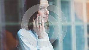 Photo business woman wearing modern suit, talking smartphone and holding papers in hands. Open space loft office