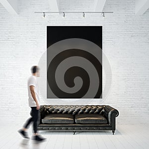 Photo of businessman in gallery. Waching black canvas hanging on the brick wall and vintage classic sofa wood floor