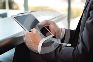 Photo of businessman using a digital tablet while sitting in the office