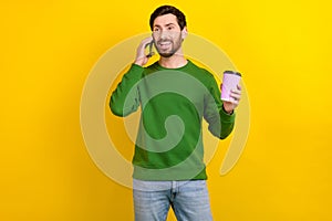 Photo of busy successful man boss wear green trendy sweater hold espresso talk phone isolated on yellow color background