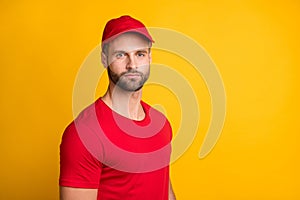 Photo of calm bristled delivery man look camera wear red t-shirt headwear isolated yellow color background