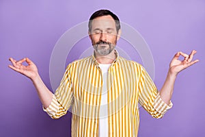 Photo of calm peaceful mature relaxed man make om signs asana good mood isolated on purple color background