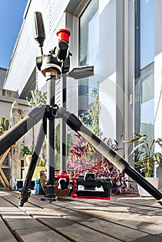 A photo camera placed on a tripod with an articulated arm to place it at ground level