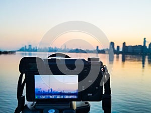 Photo camera on tripod shooting cityscape of Manhattan, NYC downtown. Early morning.