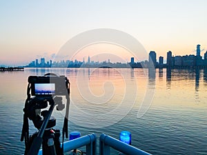 Photo camera on tripod shooting cityscape of Manhattan, NYC downtown. Early morning.