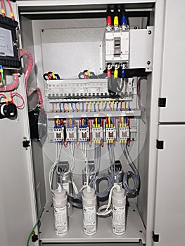 Photo of capacitor bank connection in electrical cabinet.