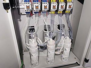 Photo of capacitor bank connection in electrical cabinet.