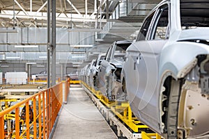 Photo of car bodies on assembly line. Factory for production of autos. Modern automotive industry. Electric car factory