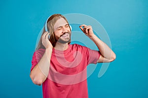 Photo of carefree cheerful person closed eyes arm touch headphones listen new single isolated on blue color background