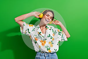 Photo of carefree youngster girl spend time outdoors wear summer shirt listen high quality headphones isolated on green