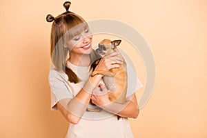 Photo of caring charming girl embrace small funny dog toothy smile wear t-shirt isolated beige color background