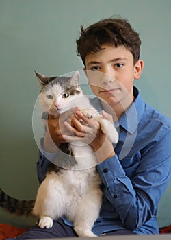 Photo of cat lover teenager boy hug cat close up funny photo