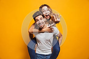Photo of caucasian couple smiling while man piggybacking excited