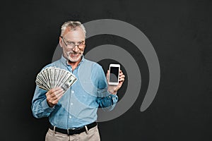 Photo of caucasian retired man 60s with gray hair holding mobile