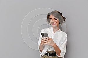 Photo of caucasian woman 20s smiling and holding mobile phone, i