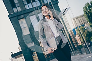 Photo of charming business woman talk phone hold computer wear formalwear jacket pants outside in outdoors