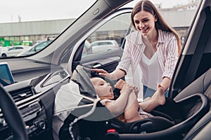 Photo of charming cheerful mom daughter wear casual outfits smiling putting safety seat inside automobile vehicle