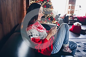 Photo of charming cute girl dressed red sweater sitting couch alone reading social media instagram telegram ennjoying