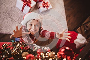 Photo of charming cute school girl wear print pullover headwear smiling hanging new year balls indoors house home room