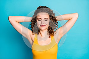 Photo of charming cute young girl hands behind head smiling nap eyes closed wear yellow singlet isolated blue color