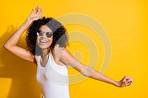 Photo of charming dark skin woman happy dance wear cool sunglass copyspace  on vibrant yellow color background