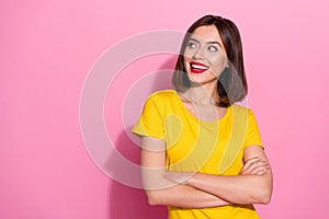Photo of charming dreamy young woman wear yellow outfit arms crossed looking empty space smiling isolated pink color