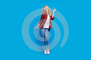 Photo of charming funky young woman dressed checkered shirt dancing smiling isolated blue color background