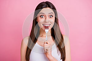 Photo of charming funny lady hold metal table fork biting teeth dreaming of tasty food dinner big desire eyes wear