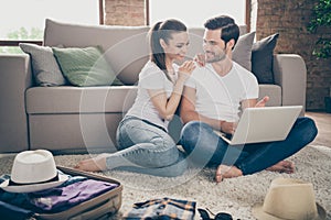 Photo of charming lady handsome guy friendly couple stay home sit floor packing stuff clothes planning trip after