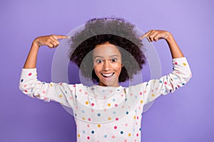 Photo of charming little dark skin girl point fingers hair volume amazed isolated on violet color background