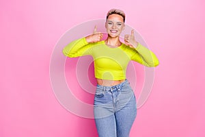 Photo of charming positive girl toothy smile demonstrate thumb up isolated on pink color background