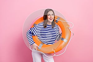 Photo of charming positive lady hold inflatable safety ring look interested empty space isolated on pink color